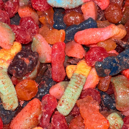 A variety of colorful gummy candies coated with a red Li Hing Mui sauce.