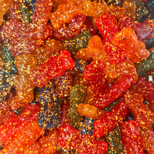 colorful sugar-coated gummy candies in red, orange, green, and dark colors