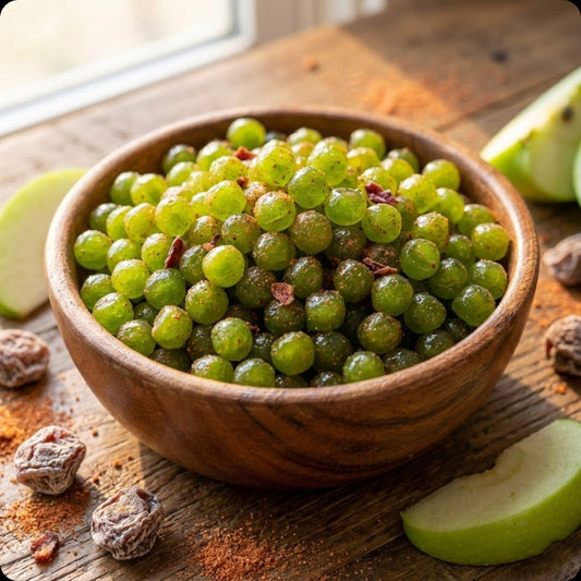 Wooden bowl filled with green-colored gummy candies coated in sugar and spice powder, surrounded by fresh green apple slices, nutmeg seeds, and cinnamon powder on a wooden surface